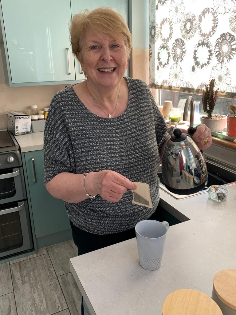 Hilary - a middle-aged woman stood in a kitchen making a cup of tea